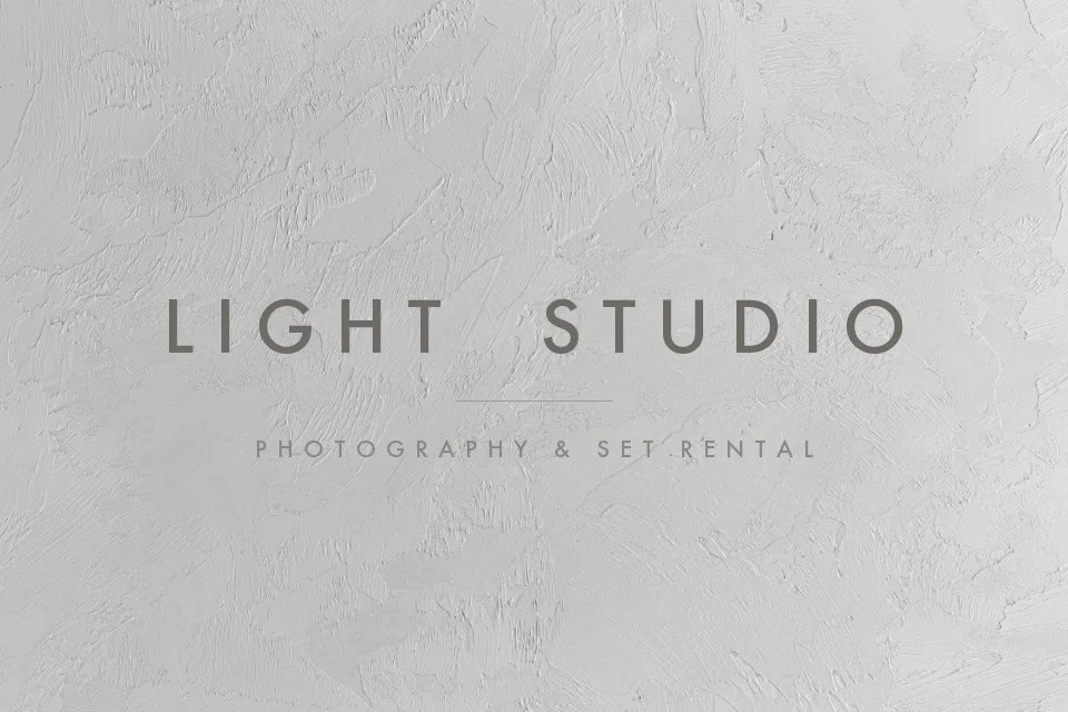 Minimal studio wordmark on a plaster wall, removed