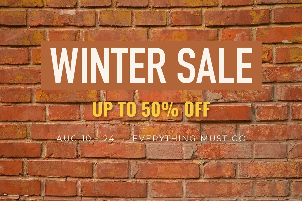 A sale poster on a brick wall where the headline was covered with a flat rectangle and retyped; the patch stands out against the bricks